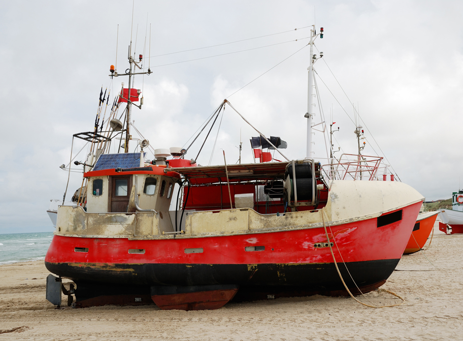Fishing boat on the sand coast.